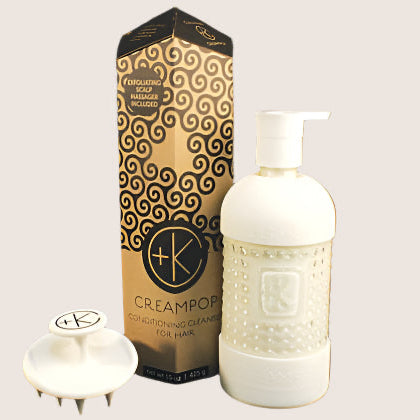 The Cult and King CREAM POP Conditioning Cleanser for Hair set features a gold and black box, a white pump bottle, and a white short-bristle scalp massager—all arranged on a light background.