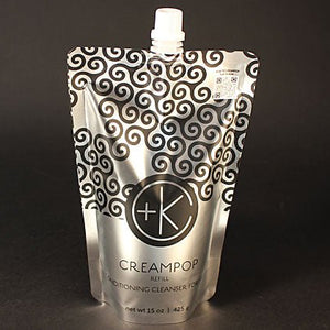 A silver refill pouch of Cult and King CREAM POP Conditioning Cleanser for Hair, featuring a white spout and black swirl pattern, stands upright against a plain black background, offering clean, shiny hair while preserving natural oils.