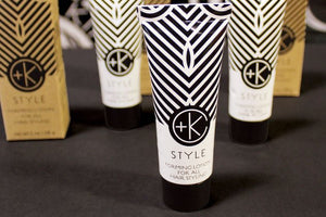 A tube of Cult and King STYLE | Forming Lotion for all Hair Styling stands upright on a black surface, with two similar tubes and two brown boxes behind it. The black-and-white geometric design suits all hair types.