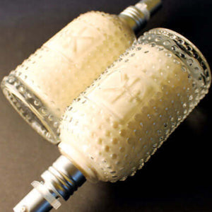 Two Cult and King glass bottles, containing Cult and King STYLE | Forming Lotion for all Hair Styling for different hair types, are placed on a black surface.