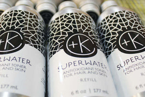 Close-up of Cult and King SUPER WATER Antioxidant Toner for Hair and Skin bottles, featuring a geometric design, "+K" logo, vegan hydration claims, and refill size of 6 fl oz (177 ml).