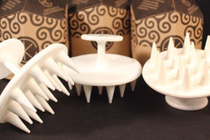 Three Cult and King Exfoliating Scalp Massagers with white pointed spikes are in the foreground, with three patterned brown and black Cult and King boxes upright in the background.