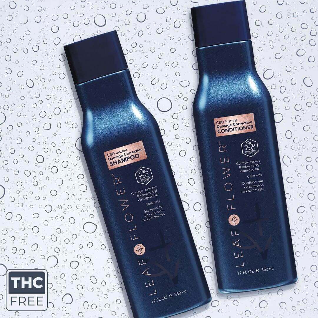 Two dark blue bottles of Leaf and Flower CBD shampoo and LEAF and FLOWER Damage Correction Conditioner rest on a speckled surface. Each 12 fl oz bottle is THC-free, featuring a plant-based, color-safe formula for vibrant, healthy hair.