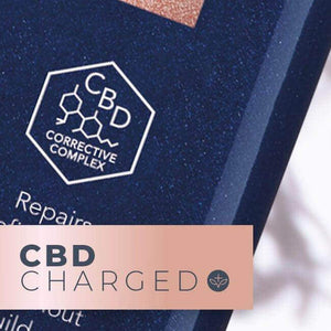 Close-up of a dark blue LEAF and FLOWER Instant Volume Conditioner label with a white hexagonal logo and "CBD Corrective Complex." "CBD CHARGED" appears on pink—a volumizing conditioner by Leaf and Flower, ideal for fine curly hair.