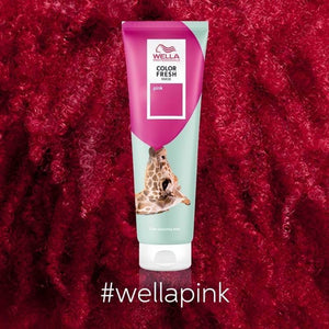 A tube of Wella Professional Color Fresh Masks - Multiple Colors by Wella, shown in pink on a textured pink background, highlights its ammonia-free formula with the hashtag #wellapink below.